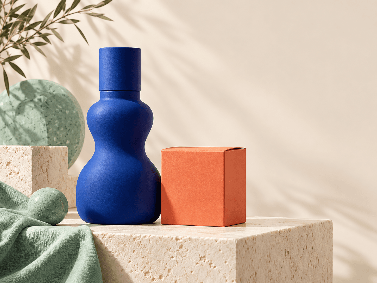 Cobalt bottle and coral product box in a warm studio setting